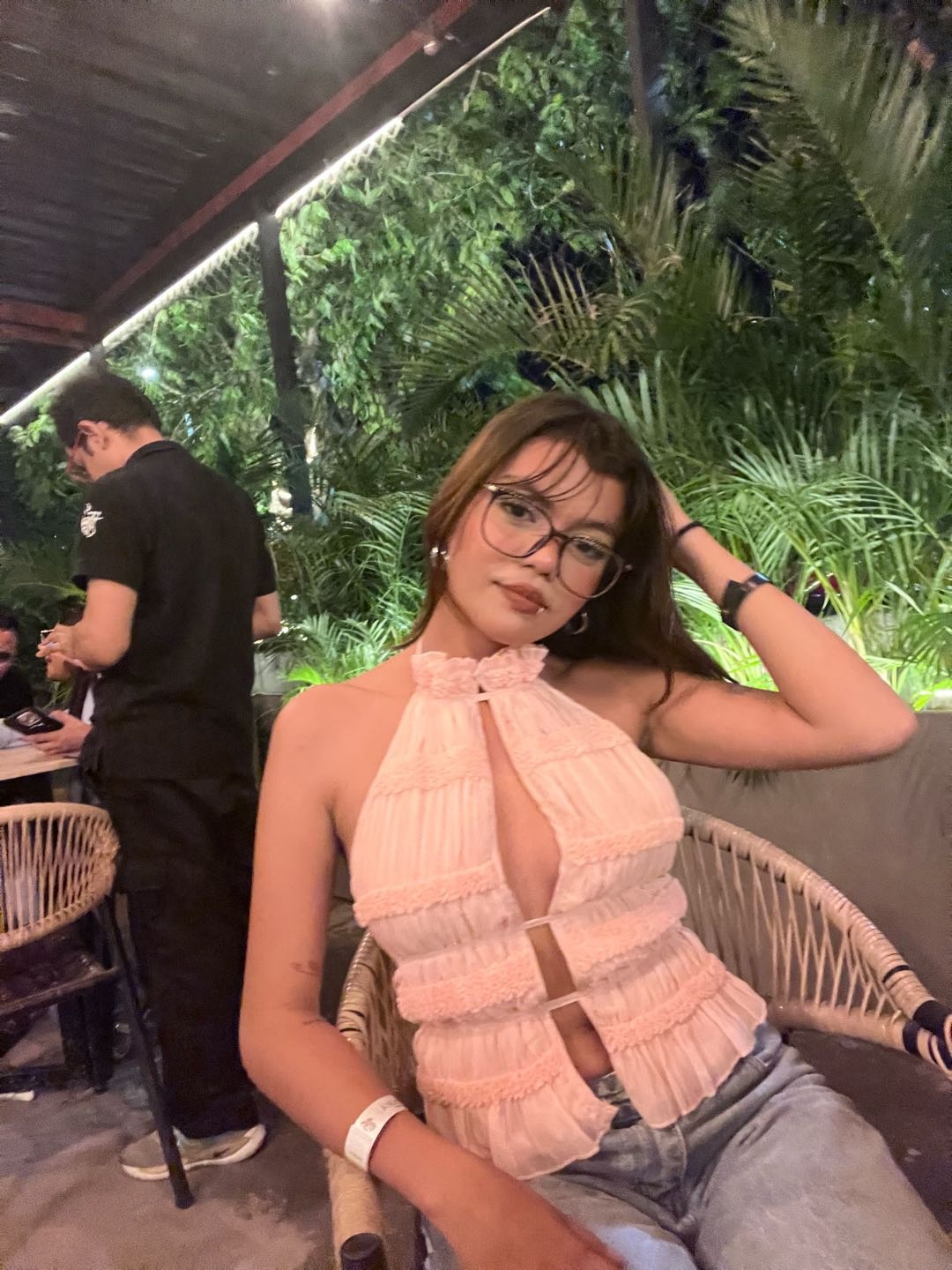 Relaxed woman with glasses sitting on a terrace in the evening